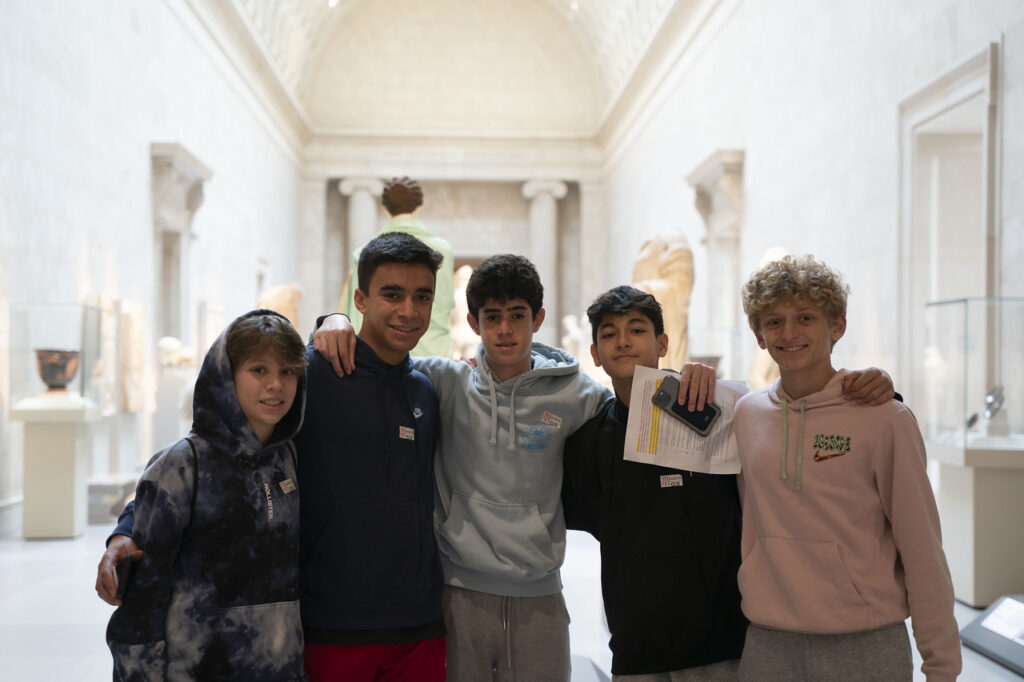 Group of Fieldston Upper students pose inside museum on field trip to Boston.