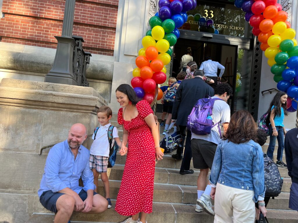 A family poses for a photo on the steps of Ethical Culture on the first day of school
