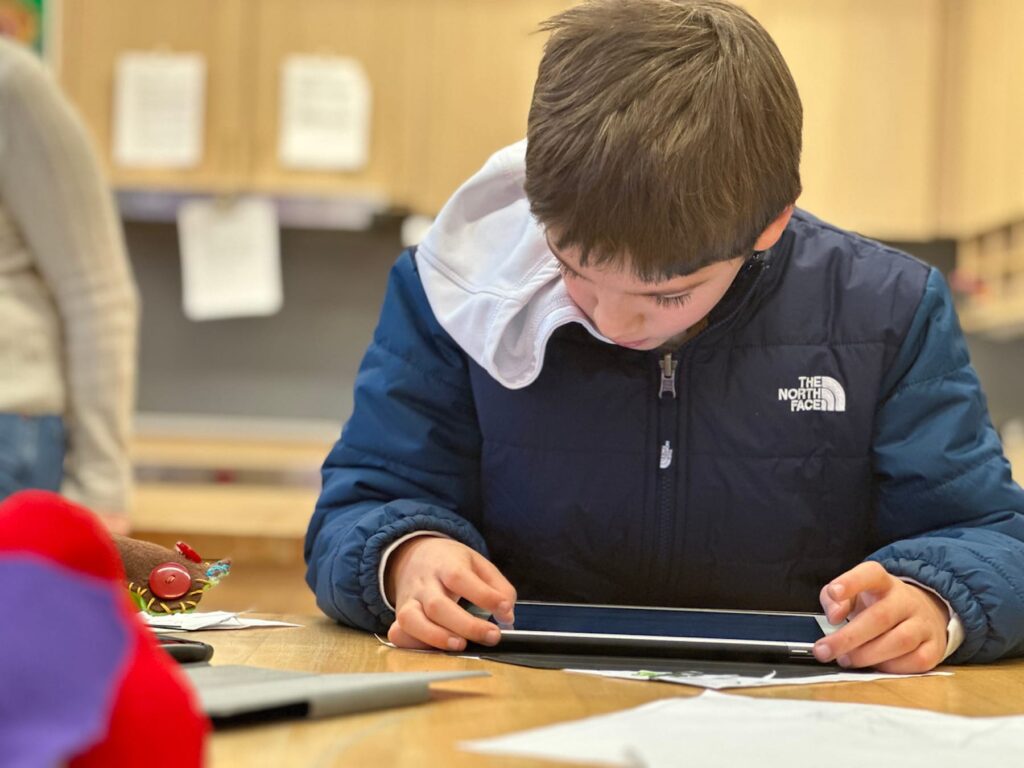 Fieldston Lower student works on his iPad in classroom.