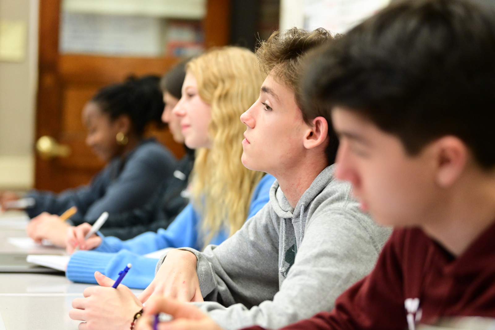 Fieldston Upper students listen on while they sit at their desks. 
