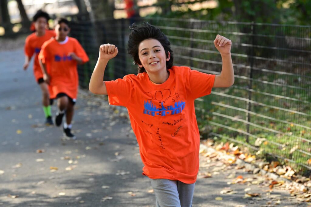 fifth grader raises arms in celebration scaled 1