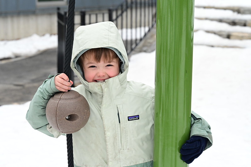 Fieldston Lower student smiles as he plays outside in the snow.