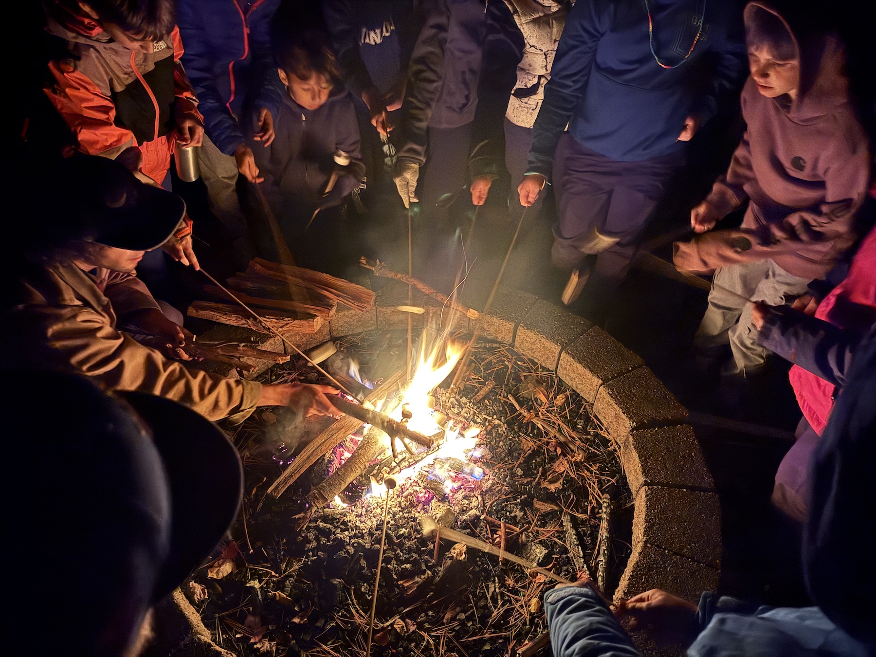 Fieldston Lower 5th Graders gather around a campfire on their Outdoor Classroom trip