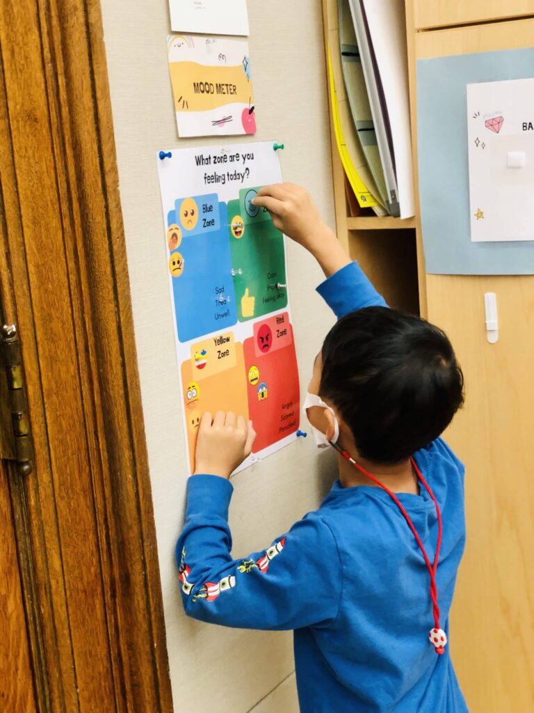 student putting a thumb tack on the mood meter scaled 1